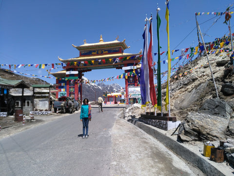 Avantika at the Sela Pass, prayer gate in the background