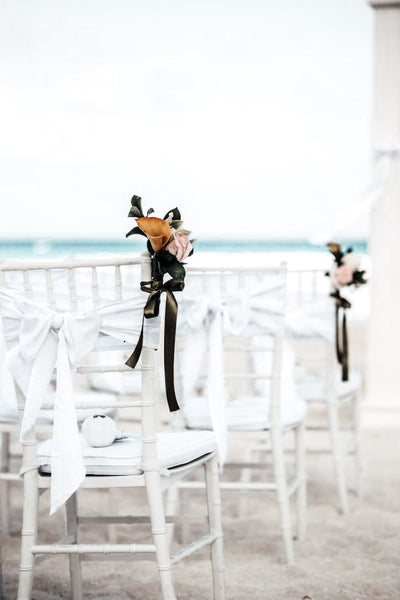 beach wedding aisle decor with white ribbon dusty rose and white flowers