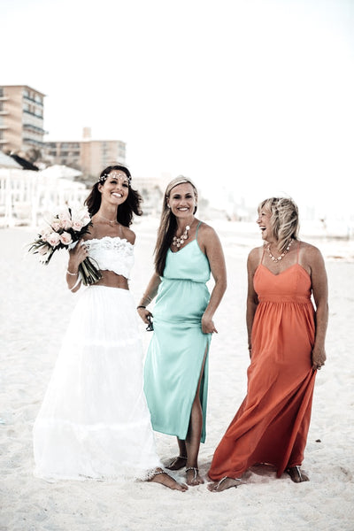 Beach Bride with her bridesmaids in their teal and coral dresses wearing foot jewelry