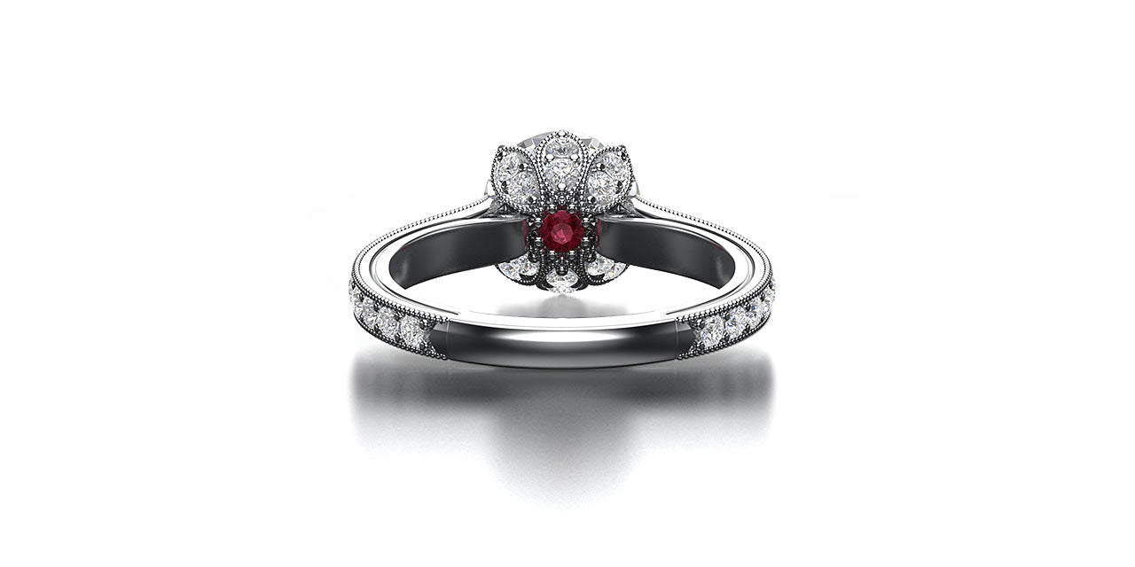 An underneath view of a platinum and diamond engagement ring with a lotus flower head and hidden garnet birthstone.