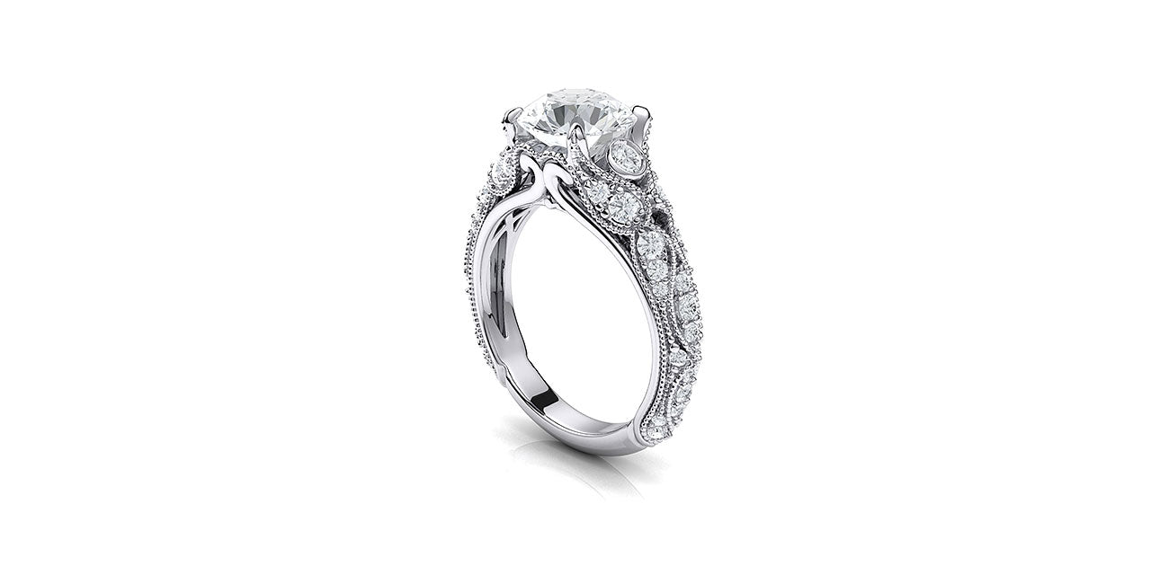 A perspective view of a vintage style diamond engagement ring with leaf and petal inspired shapes forming the sides of the ring.