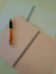 Notebook with pastel pink pages, compared to white pages