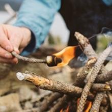 Placing the lit tinder spark into the fire pit