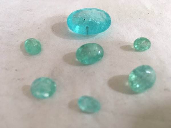 Paraiba tourmaline stones laid out on table, hand selected by Julia Lloyd George