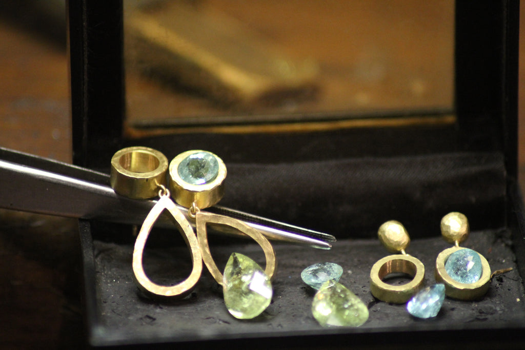 Handcrafted design process shot of paraiba tourmaline drop earrings on the work bench in Julia Lloyd George studio