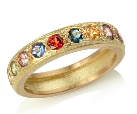 Yellow gold eternity ring set with fancy sapphires of an assortment of colours with engraved pattern detail