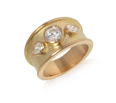Large yellow gold ring set with one brilliant cut diamond and two pear shaped diamonds either side