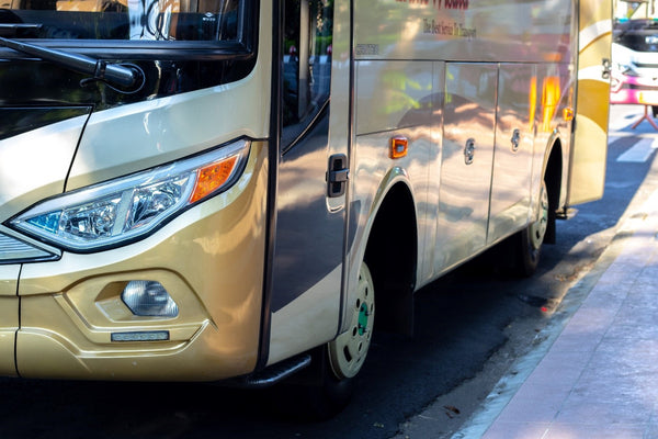 Golden bus parked up on the side of the road