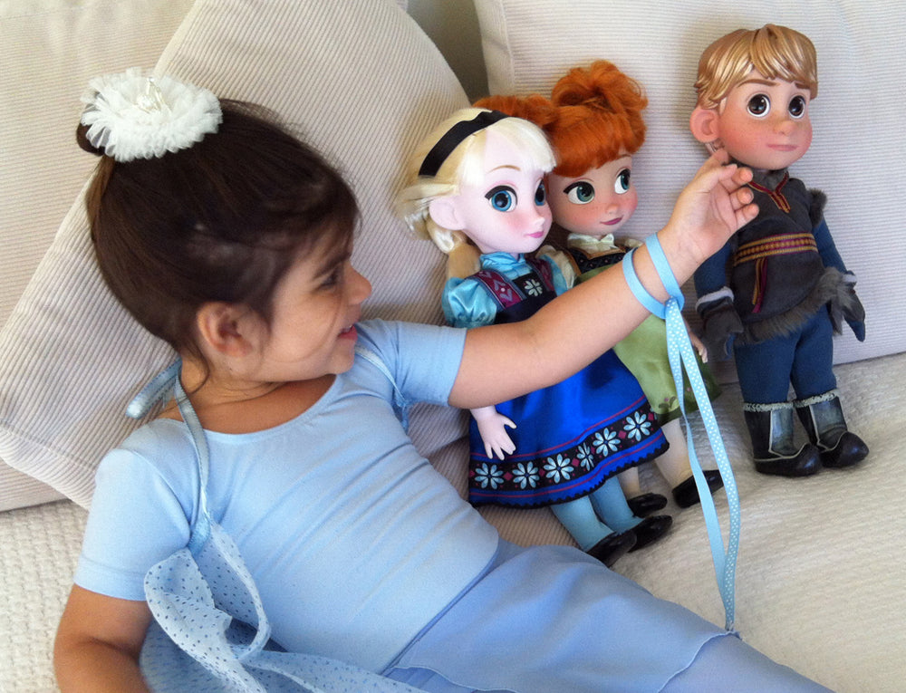 Girl playing with Disney Frozen dolls