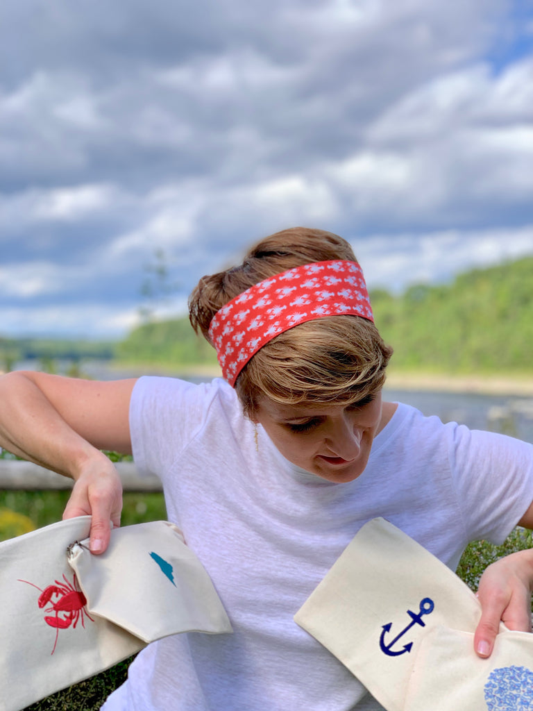 girl holding Maine themed cosmetic bags