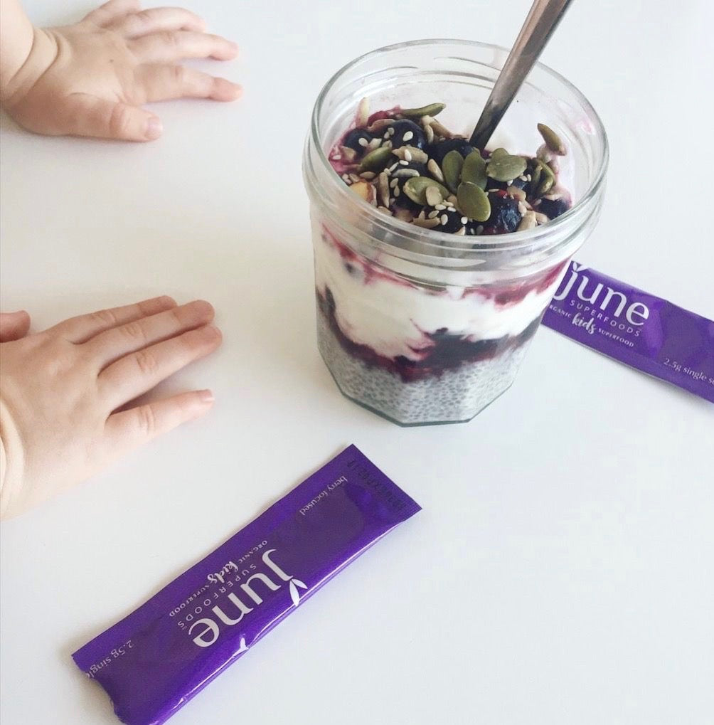 chia seed yogurt parfait with berry superfoods and kids hands