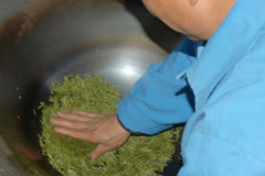 Tea Master hand roasting long jing leaves