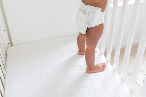 Baby standing wearing only a diaper