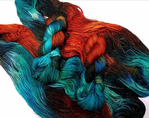Gorgeous intensely dyed yarn. Orangey reds, teal and brown black on a sparkly base