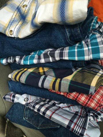 Pile of folded jeans and button-down shirts