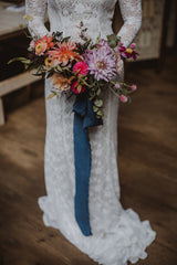 Bride hold a wedding bouquet with navy blue ribbon by The Lesser Bear Florals by Old Slate Farm Photo by Rosemill Media