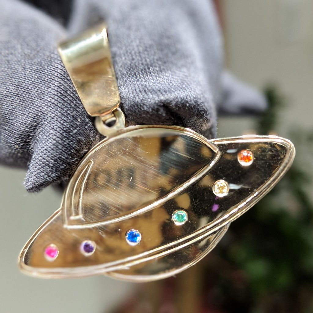 Custom gold UFO pendant, replete with colored gemstones. The original pictured here was made for our client Demetrius @youngpopss