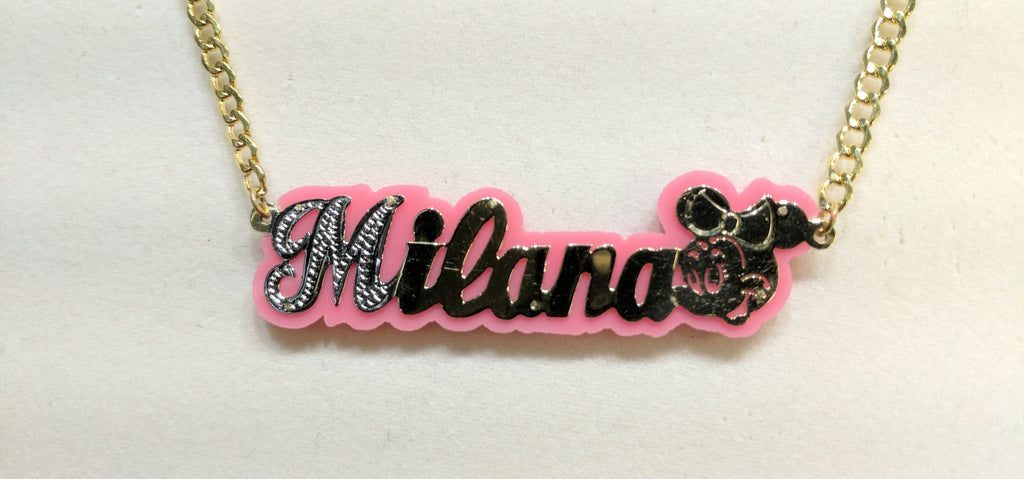 In the center: a custom made name plate flat cuban necklace for Milana in 14 karat yellow gold with white bead work high polish finish and Walt Disney Minnie Mouse face at the end by Popular Jewelry