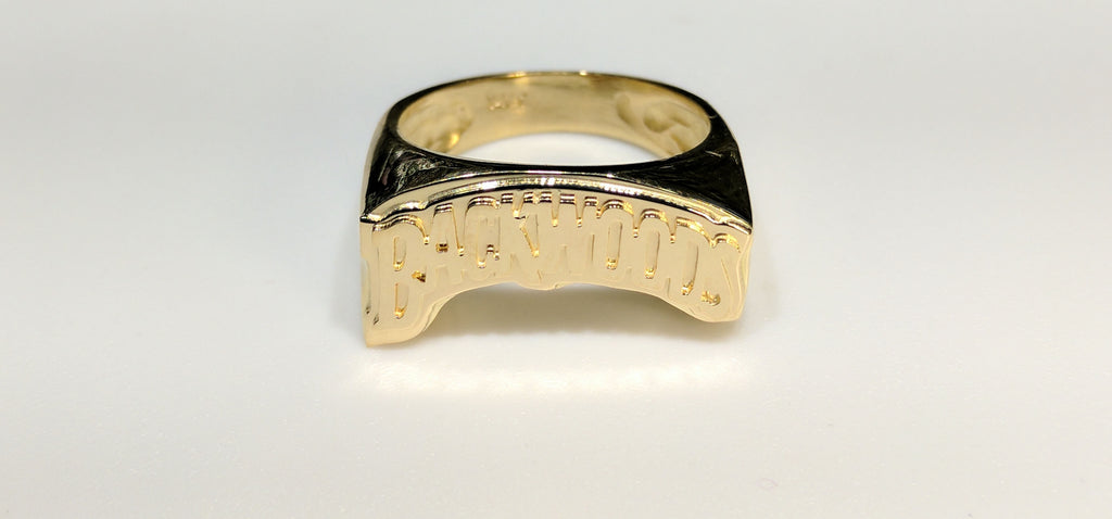 In the center: a custom made name ring stylized Backwoods in 14 karat yellow gold high polish finish double layer made by Popular Jewelry in New York City