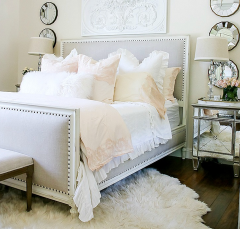pink and white bedding on a bed in a fancy bedroom