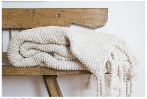 white knit throw folded on a bench