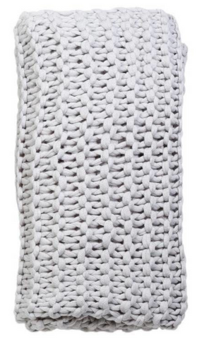 A silver grey chunky knit throw