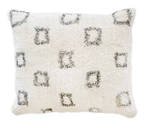 A large furry white pillow with grey square pattern