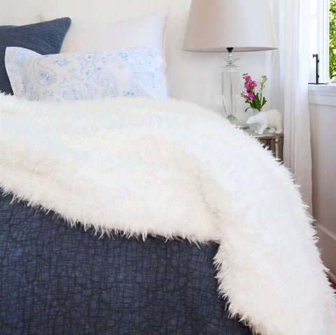 fluffy white throw on blue bed