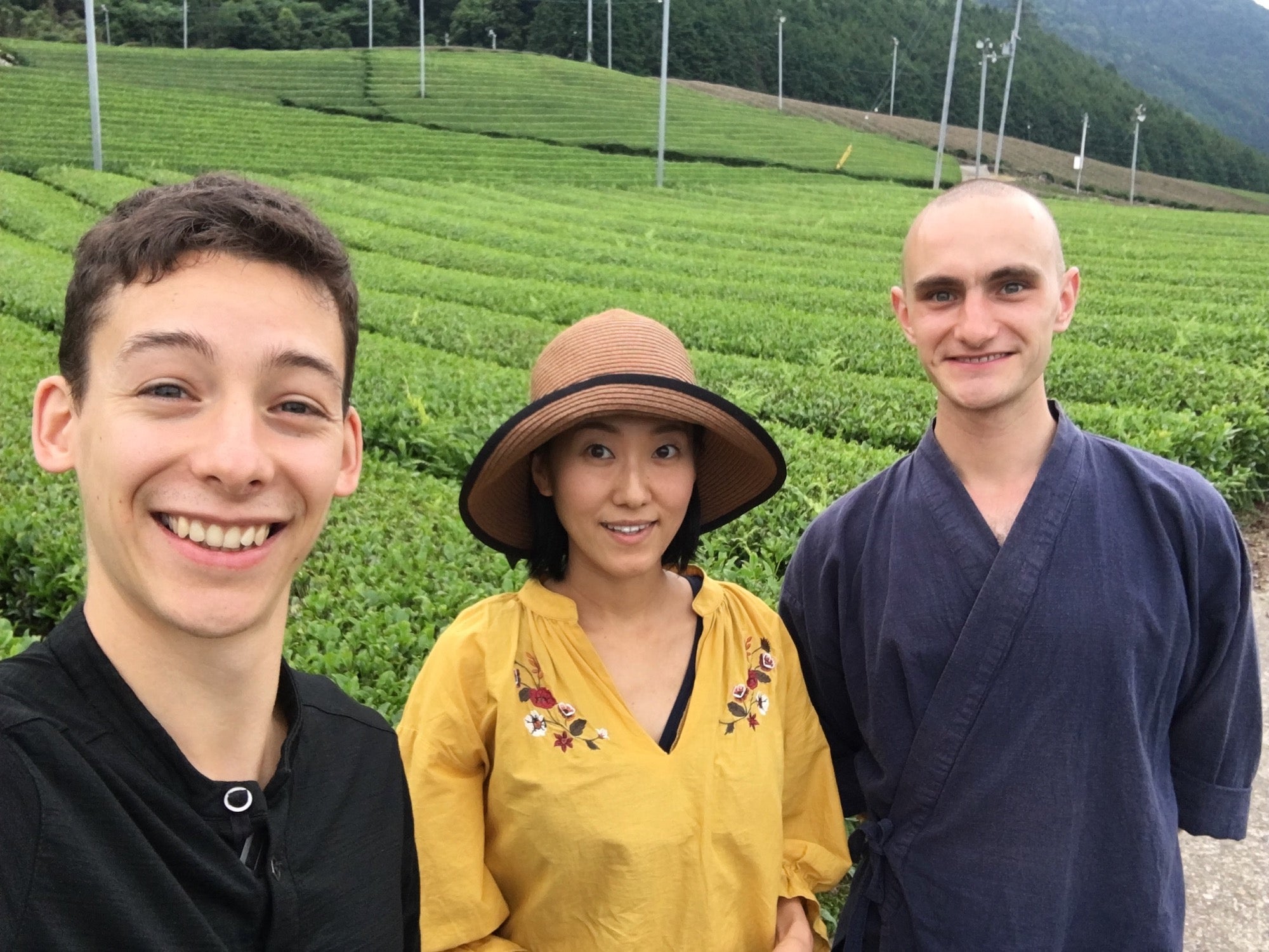 une agricultrice, Tyas et Valentin devant des champs de thé 