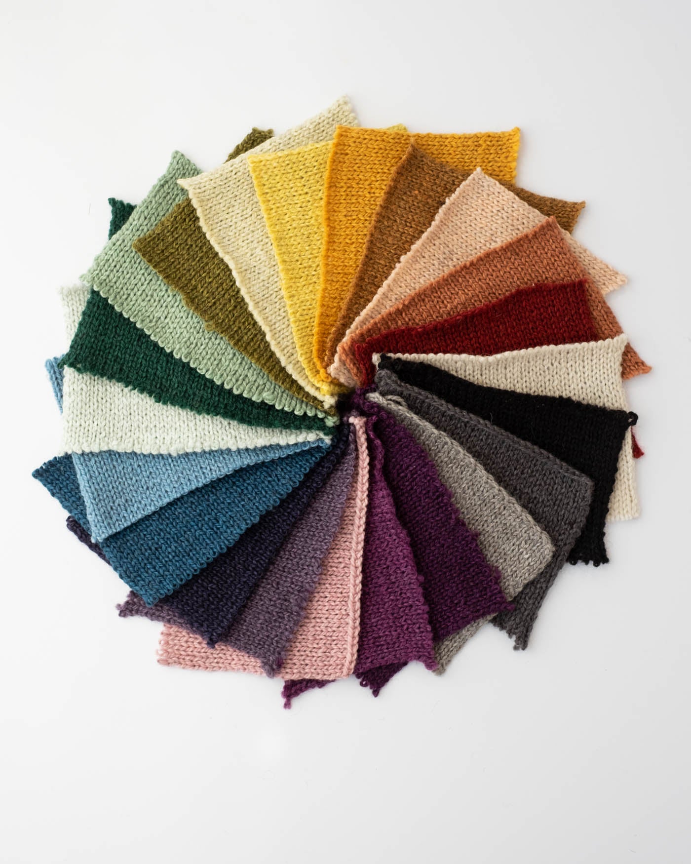 Rectangular knit swatches in the color of the rainbow in a circle to show all 22 colors.