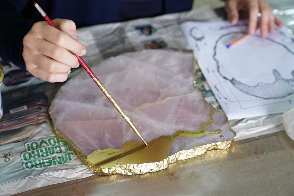 Anna painting a large coaster