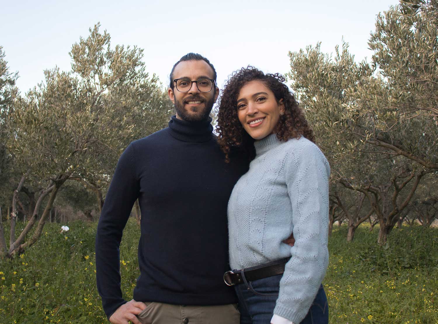 Skyler and Giuseppe posing in front of olive trees