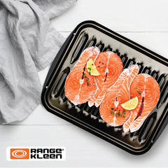 White countertop with shiny black broiler pan featuring raw salmon steaks on pan. Range Kleen logo on bottom left corner.