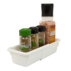 White background with white expandable bin, expanded,  holding various spice jars.