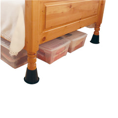 Black risers support wooden bed frame, creating additional space for clear storage tubs under the bed.