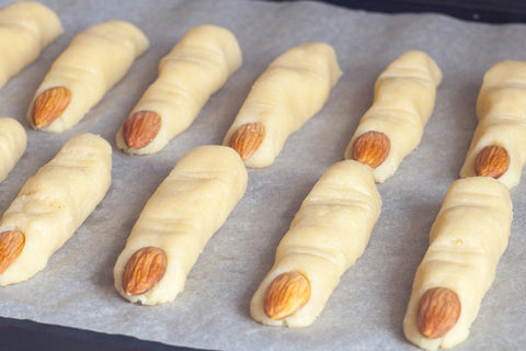 Sugar cookie dough shaped to resemble fingers with almonds to resemble finger nails.