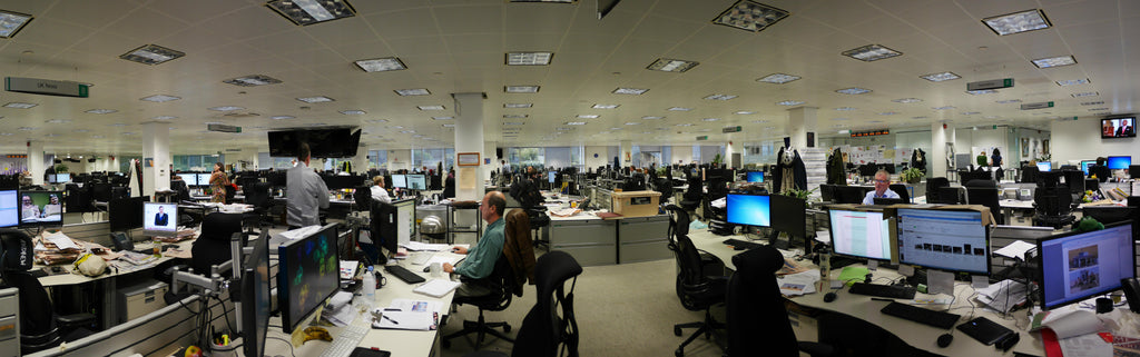 large newspaper newsroom with workers at their desks