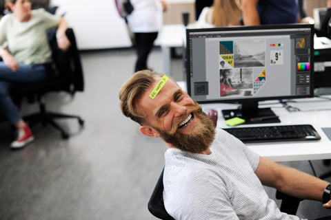 office worker laughing by his computer
