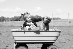 little girl and a puppy in a wagon