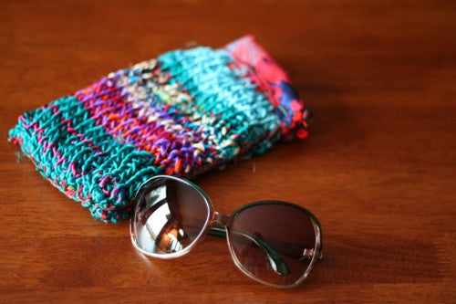 yarn project with glasses next to it