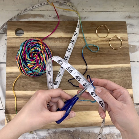 Scissors cutting multicolored yarn at 46" long