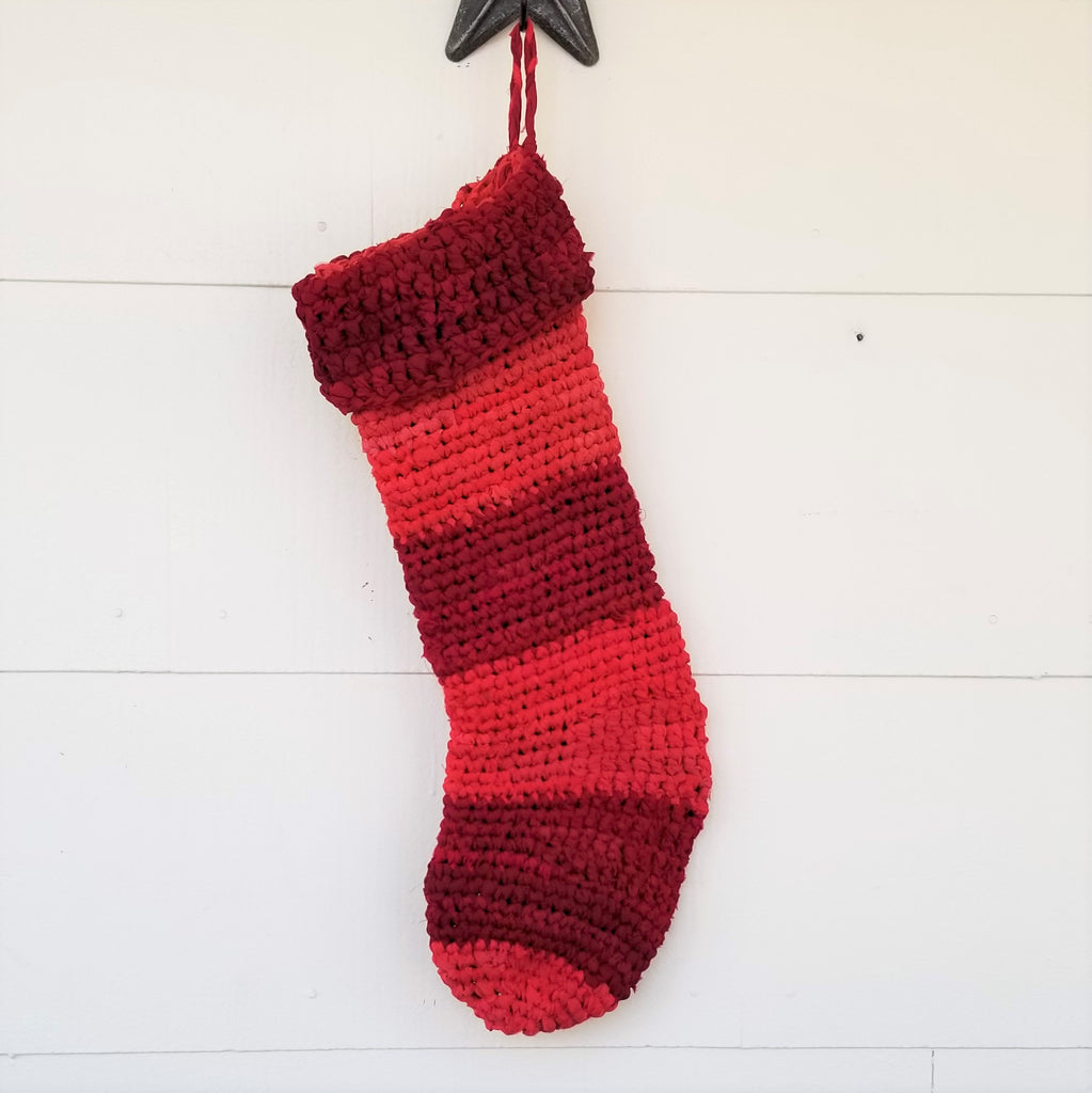 Red striped crochet Christmas Stocking hanging on a white wall
