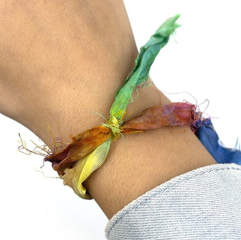 Woman's wrist with a silk ribbon tied around on a white background