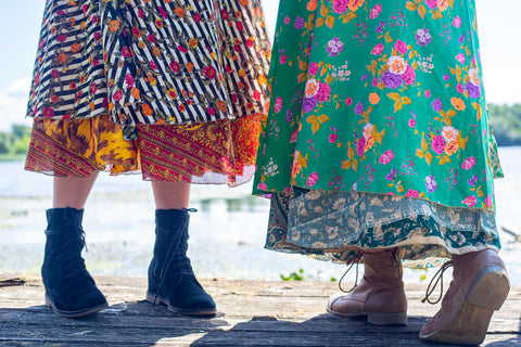 Close up of two women wearing Sari Wrap Skirts with Boots and Booties and standing on a wooden surface