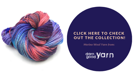 Ball of pink and purple yarn on a white background with a round purple text box that reads 'click here to check out the collection of Merino Wool Yarn from Darn Good yarn'