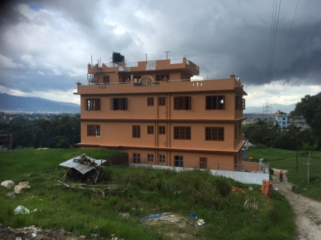 Large tan-colored building standing in an open field