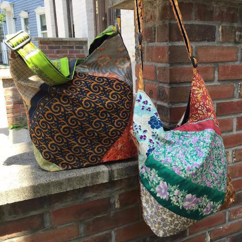 2 One of a Kind Sari Silk Purses hanging on a brick wall