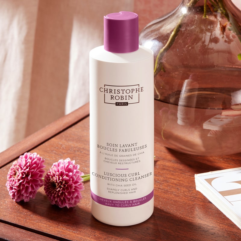 Christophe Robin Luscious Curl Conditioning Cleanser on table with flowers