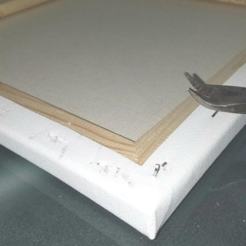 Pulling staples out of a canvas frame for the heat transfer vinyl project