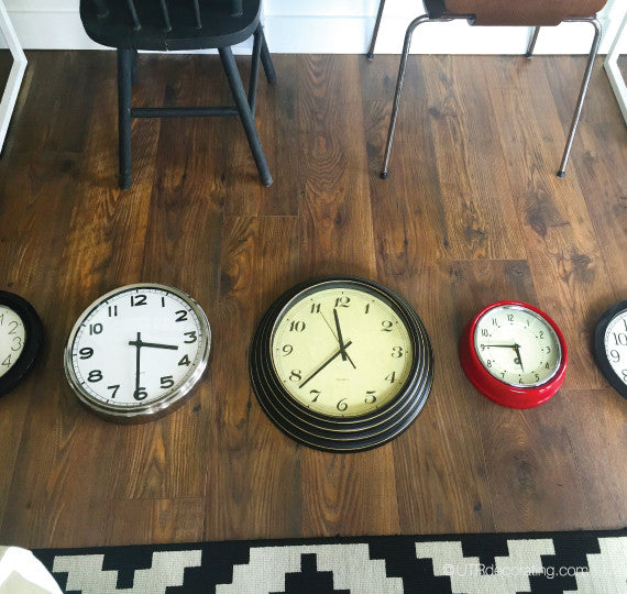 clocks laid out in front of the wall to plan the display